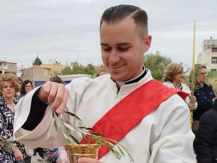 El sacerdote Miguel Tovar, bendiciendo una rama de olivo.