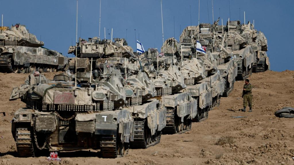 Un soldado israelí camina junto a vehículos militares en Gaza este miércoles.