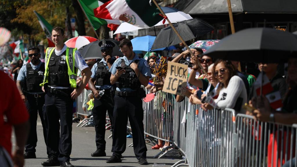 Personas ondean banderas mexicanas durante el desfile del Día de la Independencia de México en Chicago, Illinois, EE. UU.