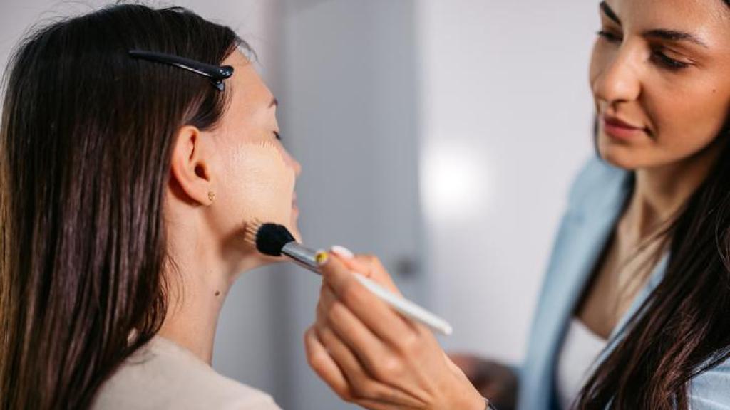 Mujer siendo maquillada por una profesional.