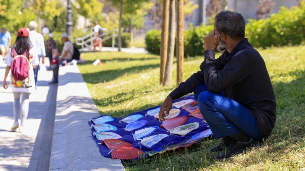Un hombre a la sombra se resguarda del sol y del calor en Madrid.