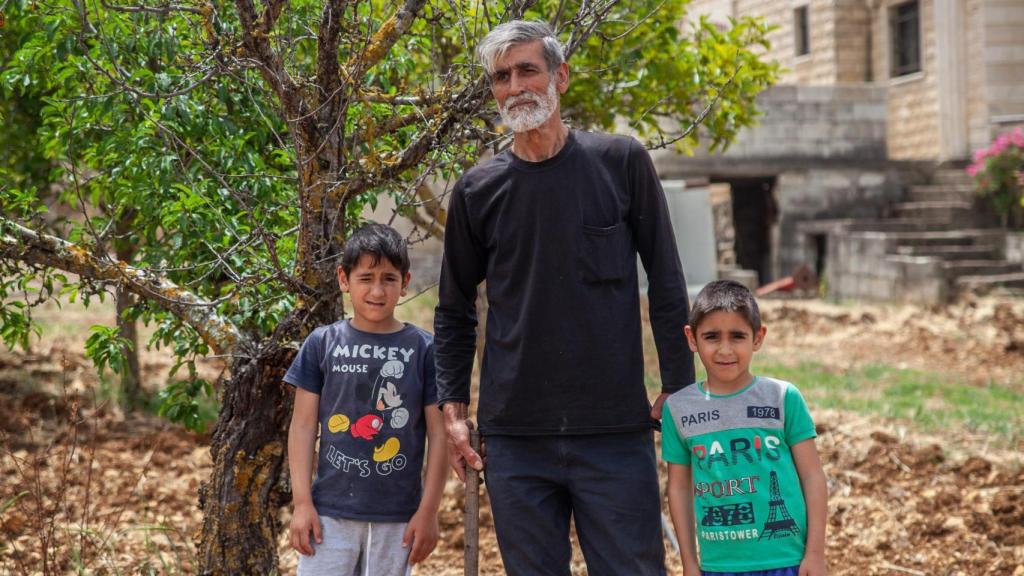 Jaafar junto a sus hijos en su campo de cultivo.