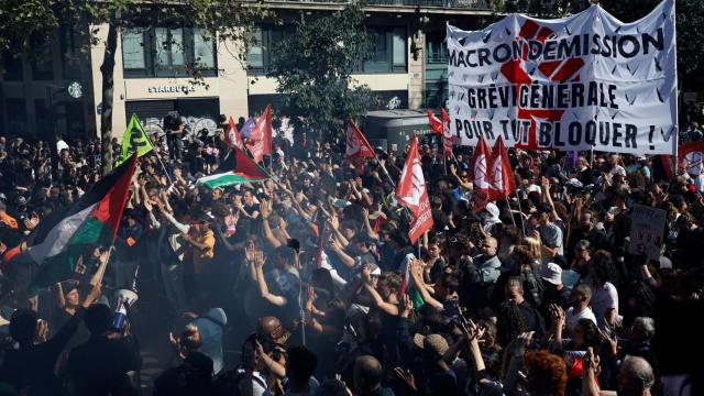 Manifestantes sostienen una pancarta con el lema Macron, ¡dimite! Huelga general para bloquearlo todo, en París.