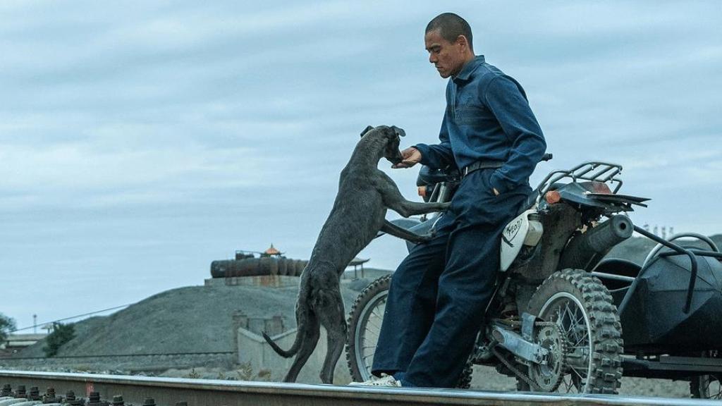 El actor Eddie Peng con el perro negro Xin, el coprotagonista canino, en una escena de 'Black Dog'.