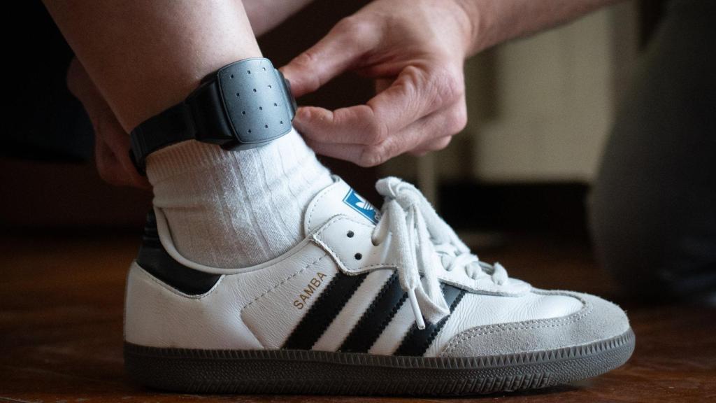 Una persona le pone una pulsera de localización a otra