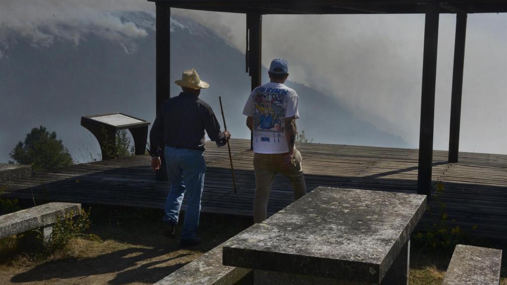 Varias personas observan el incendio desde el mirador de A Lampa en la aldea de Moura, a 19 de septiembre de 2025, en Nogueira de Ramuín, Ourense, Galicia (España).