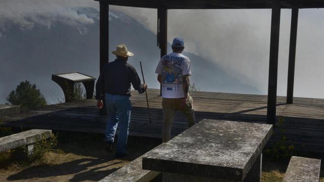 Varias personas observan el incendio desde el mirador de A Lampa en la aldea de Moura, a 19 de septiembre de 2025, en Nogueira de Ramuín, Ourense, Galicia (España).
