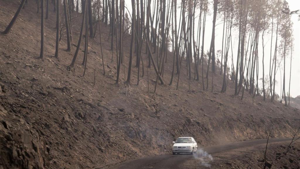 Un coche circula al lado del terreno calcinado, a 20 de septiembre de 2025, en A Barca, Sober, Lugo, Galicia (España).