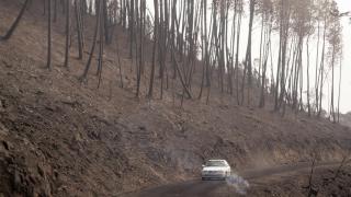 Un coche circula al lado del terreno calcinado, a 20 de septiembre de 2025, en A Barca, Sober, Lugo, Galicia (España).