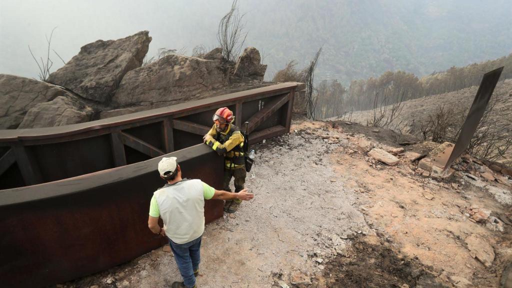 Un brigadistas forestal y un vecino de la zona hablan del terreno calcinado, a 20 de septiembre de 2025, en A Barca, Sober, Lugo, Galicia (España).