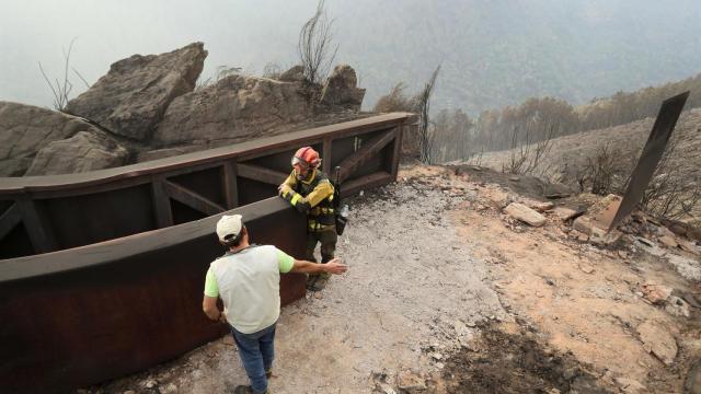 Un brigadistas forestal y un vecino de la zona hablan del terreno calcinado, a 20 de septiembre de 2025, en A Barca, Sober, Lugo, Galicia (España).