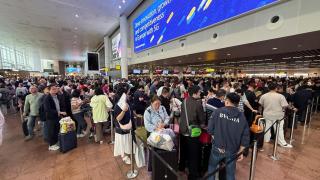 Cientos de viajeros hacen cola en el aeropuerto de Bruselas, este domingo.