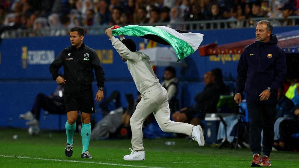 Un espontáneo salta al terreno de juego del Johan Cruyff con una bandera de palestina durante el Barça - Getafe.