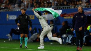 Un espontáneo salta al terreno de juego del Johan Cruyff con una bandera de palestina durante el Barça - Getafe.