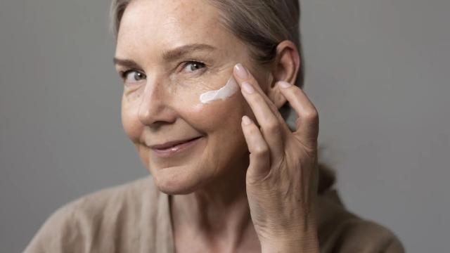 Mujer aplicándose crema en la cara.