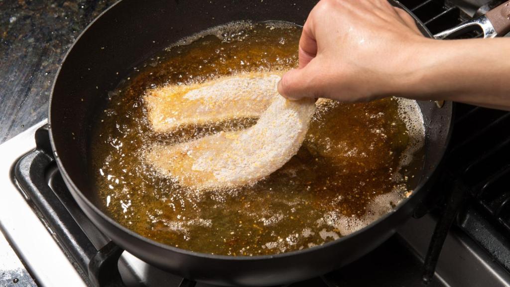 Friendo pescado en la sartén.