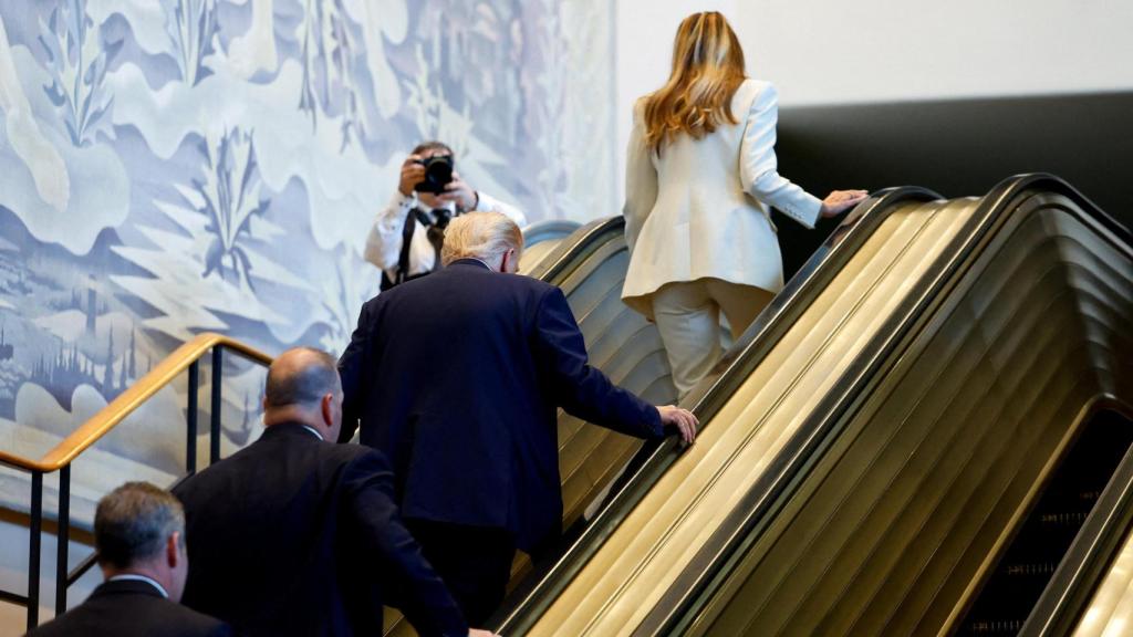 Trump y Melania subiendo la escalera.