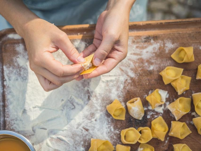 Imagen de archivo de un niño preparando tortellinis.
