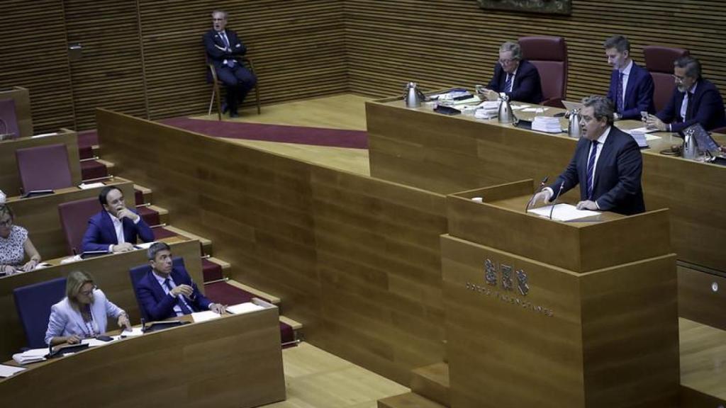 El portavoz de Vox, José María Llanos, en la tribuna de Les Corts bajo la mirada de Mazón. José Cuéllar / Corts