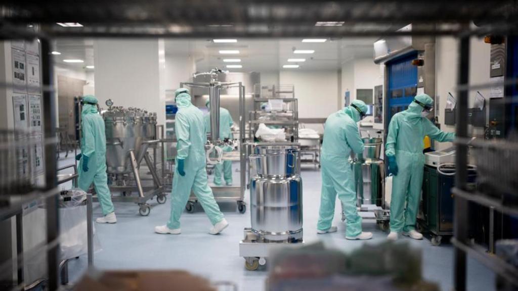 Cinco operarios trabajan en un laboratorio.