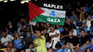 Un aficionado es fotografiado con una bandera palestina dentro del estadio del Nápoles.