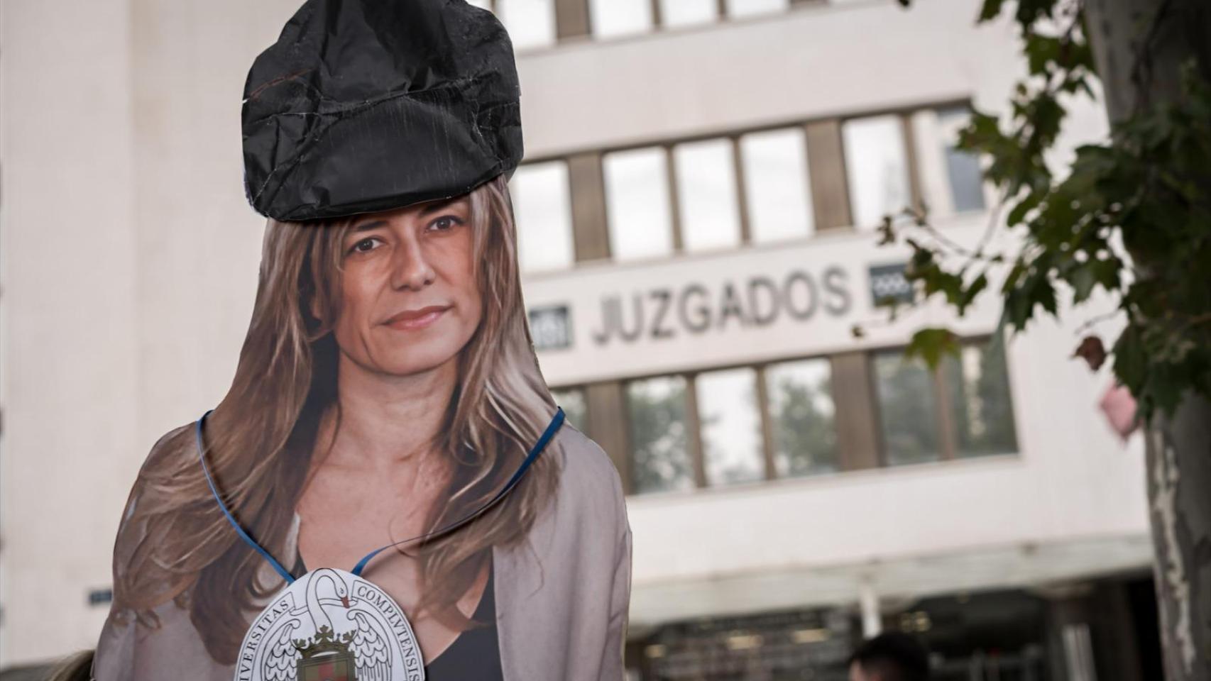Un manifestante exhibe una figura de Begoña Gómez ante los juzgados de Plaza de Castilla.