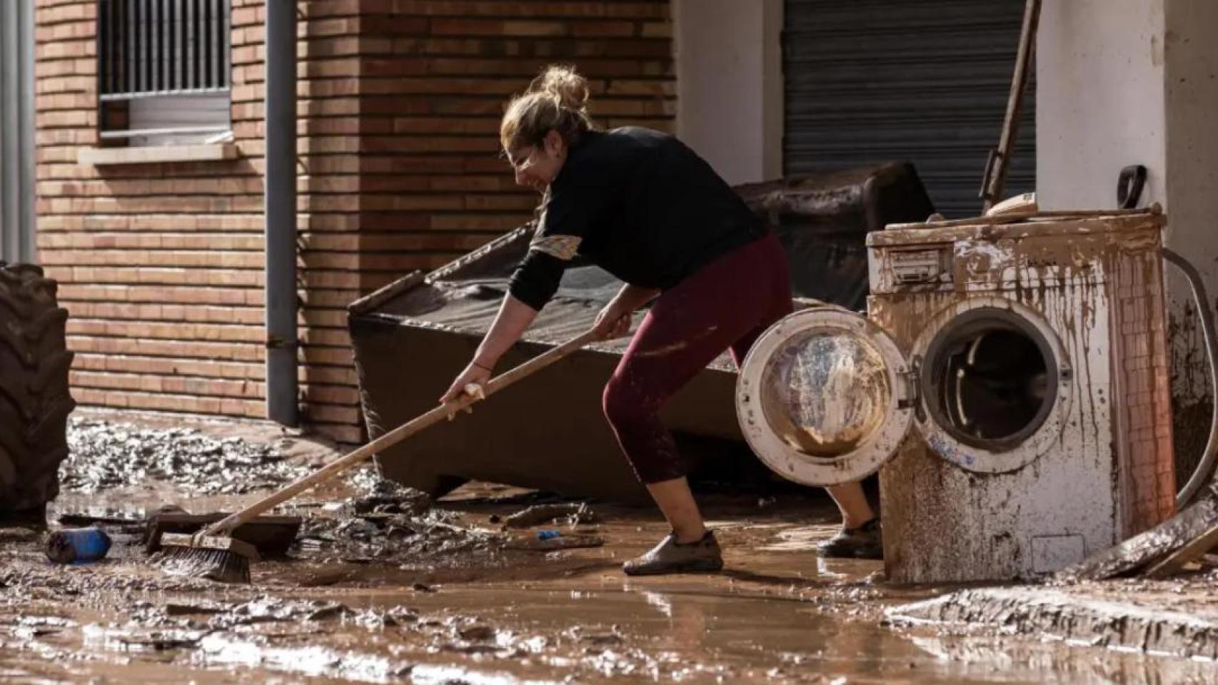 Una mujer limpia los estragos dejados por la dana en Utiel, Valencia. Diego Radamés / Europa Press