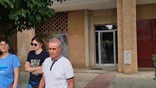 Vecinos de Sevilla Este pasan delante del portal donde se ha producido el crimen.