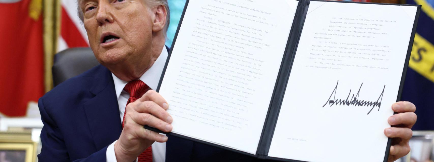 Donald Trump posa con una orden ejecutiva.