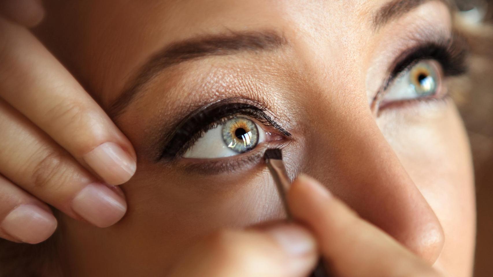 Imagen de archivo de una mujer pintándose el ojo.