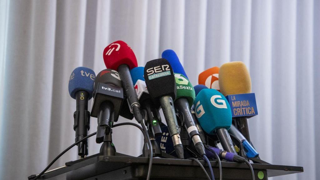 Micrófonos de distintas cadenas de televisión en una rueda de prensa.