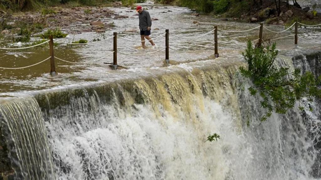 Un hombre cruza andando un badén inundable en el municipio valenciano de Artana este lunes.
