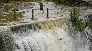 Un hombre cruza andando un badén inundable en el municipio valenciano de Artana este lunes.