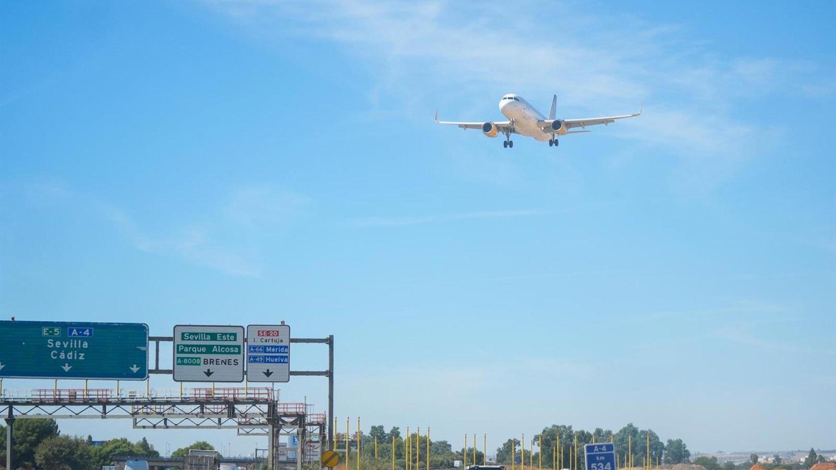 Imagen de un avión sobrevolando una carretera de Sevilla.