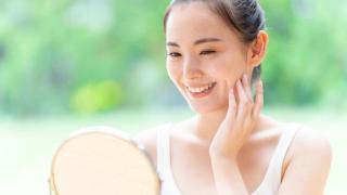 Mujer japonesa mirándose a un espejo de mano.