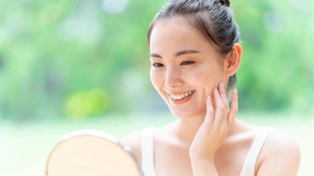 Mujer japonesa mirándose a un espejo de mano.