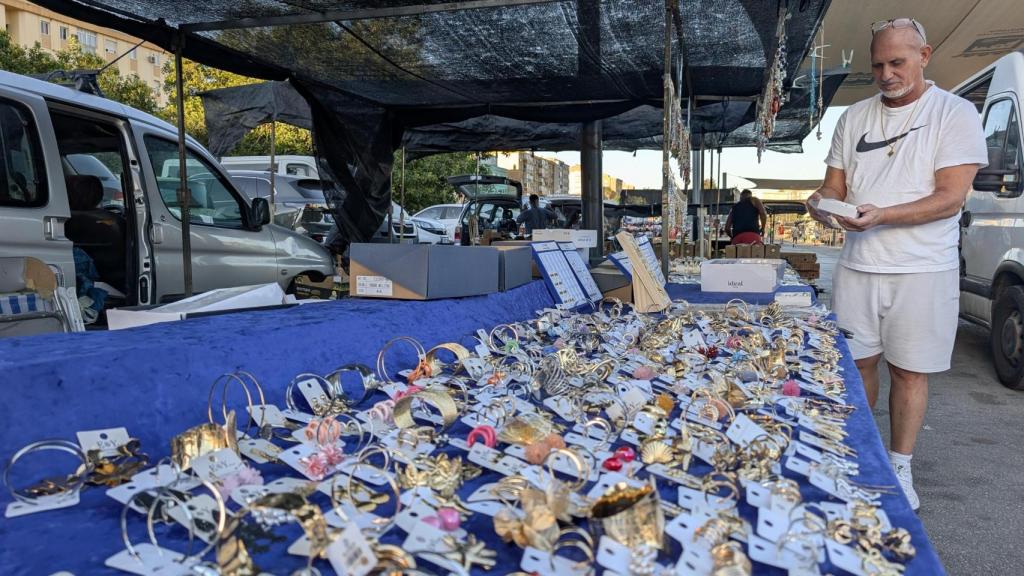 Enrique coloca bisutería sobre la mesa.