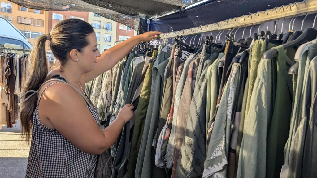 Miriam, vendedora, colocando ropa en su puesto.
