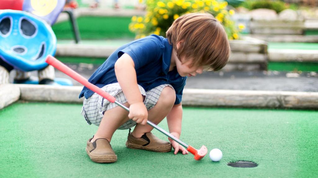 Una foto de archivo de un niño en el minigolf.