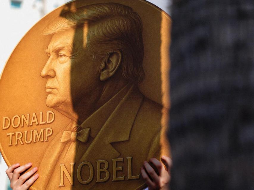Un manifestante sostiene un cartel con una imagen que representa al presidente de Estados Unidos, Donald Trump, y la palabra Nobel escrita en él.