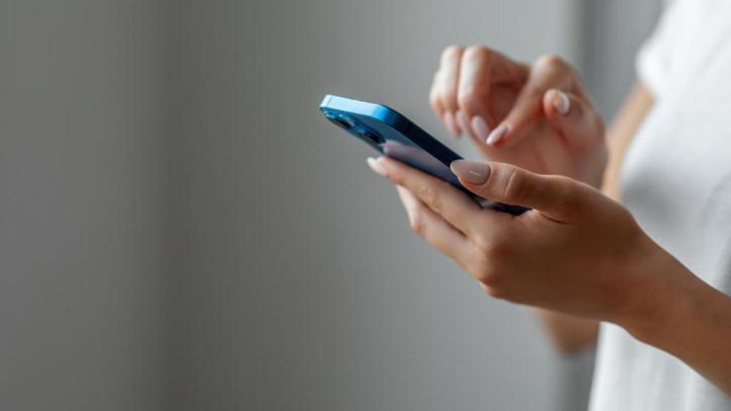 Mujer con el móvil entre las manos.