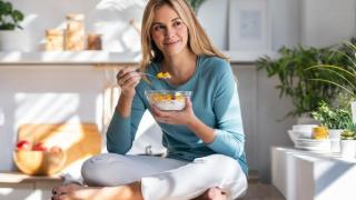 Mujer comiendo fruta con yogur.