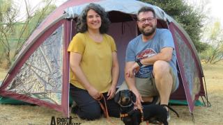 Dos clientes de 'DogAventure' en una tienda de campaña con su perro.