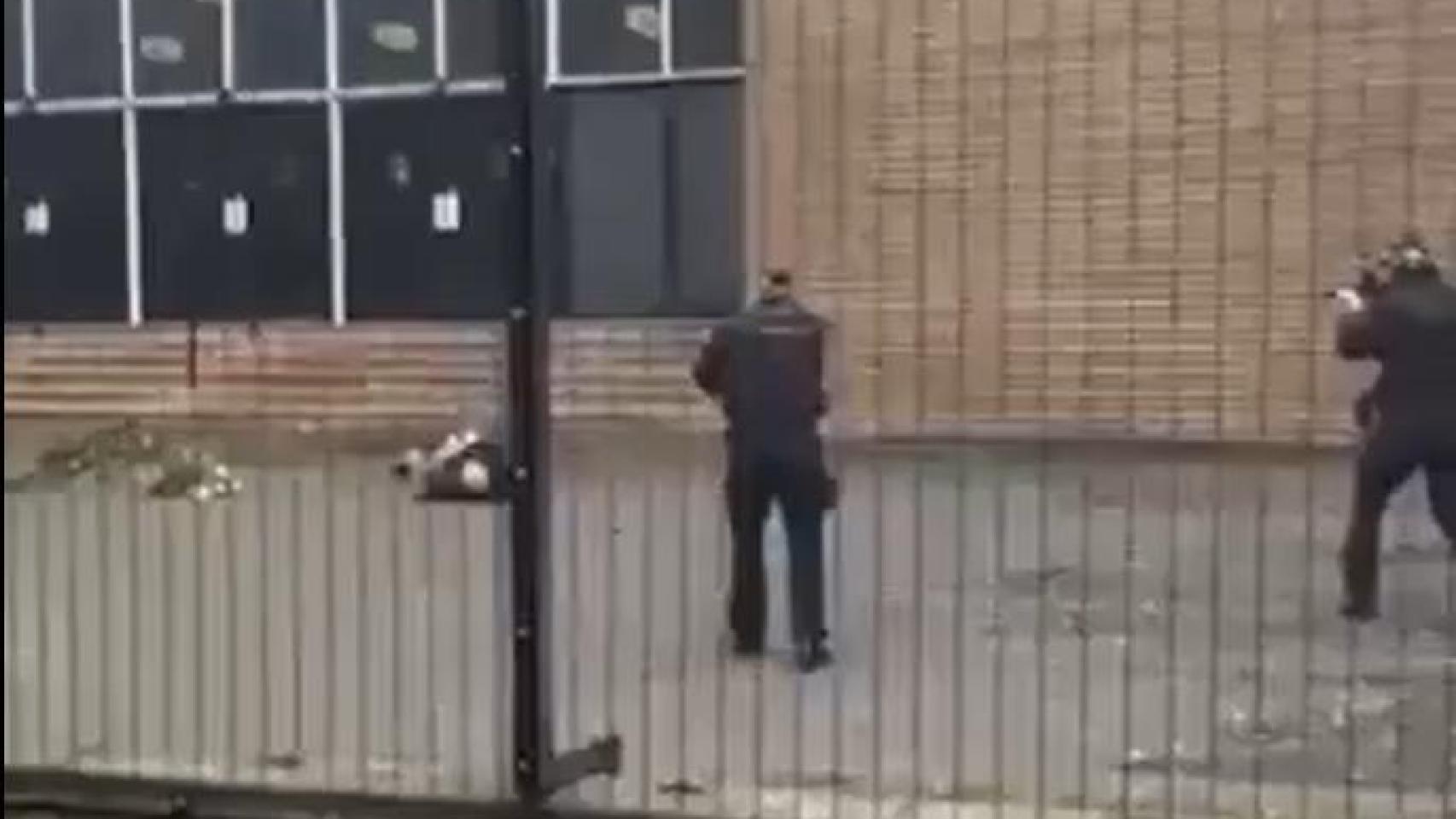 Dos agentes apuntan al sospechoso del ataque, herido en el suelo, antes de disparar.