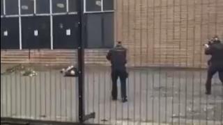 Dos agentes apuntan al sospechoso del ataque, herido en el suelo, antes de disparar.