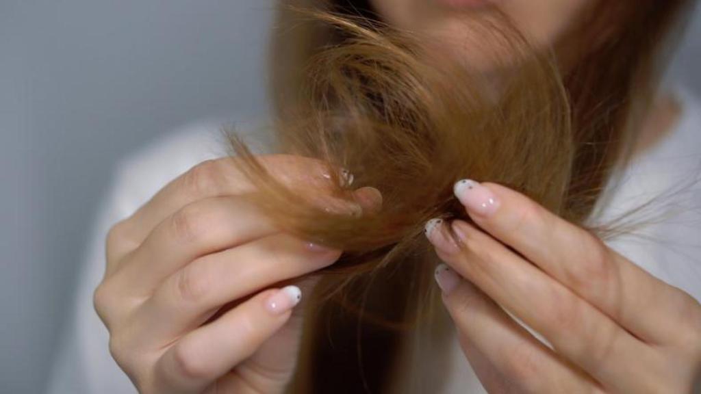 Mujer con las puntas del cabello dañadas.