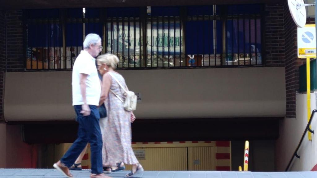 Dos transeúntes caminan frente a la entrada del garaje de la comunidad donde Negreira se hospeda durante sus temporadas en Alicante.
