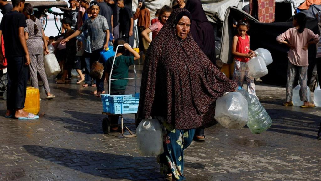 Gazatíes van a buscar agua tras el anuncio del plan de paz
