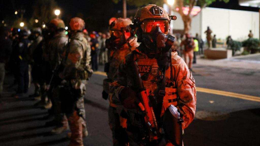 Agentes del orden hacen guardia en las afueras de la sede del Servicio de Inmigración y Control de Aduanas (ICE) de EEUU.