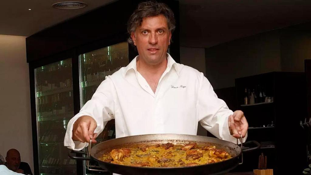 Vicente Rioja, chef valenciano, sostiene una paellera durante la preparación del plato.